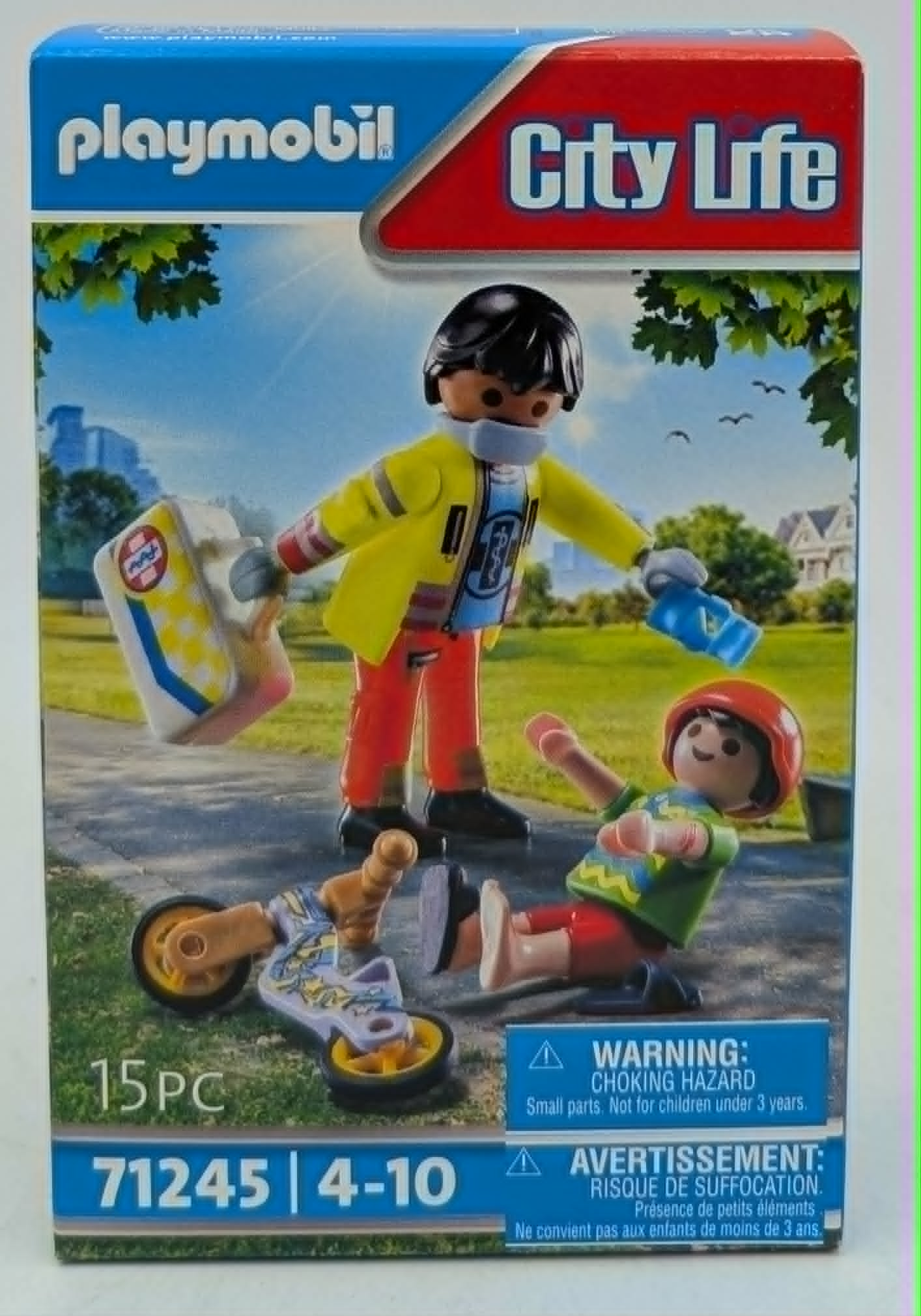 Playmobil-Figuren: Ein Erwachsener mit gelber Jacke hilft einem Kind nach einem Sturz vom Fahrrad.
