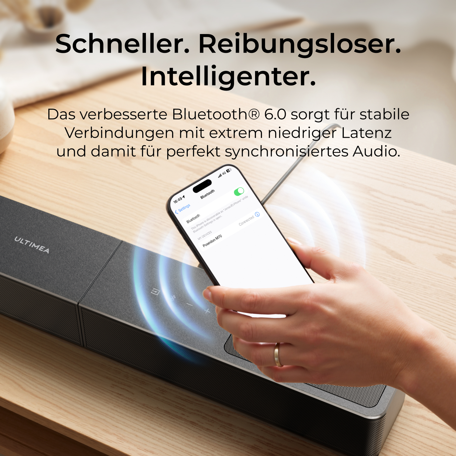 Eine Hand hält ein Smartphone über einer schwarzen Soundbar. Bluetooth ist verbunden.