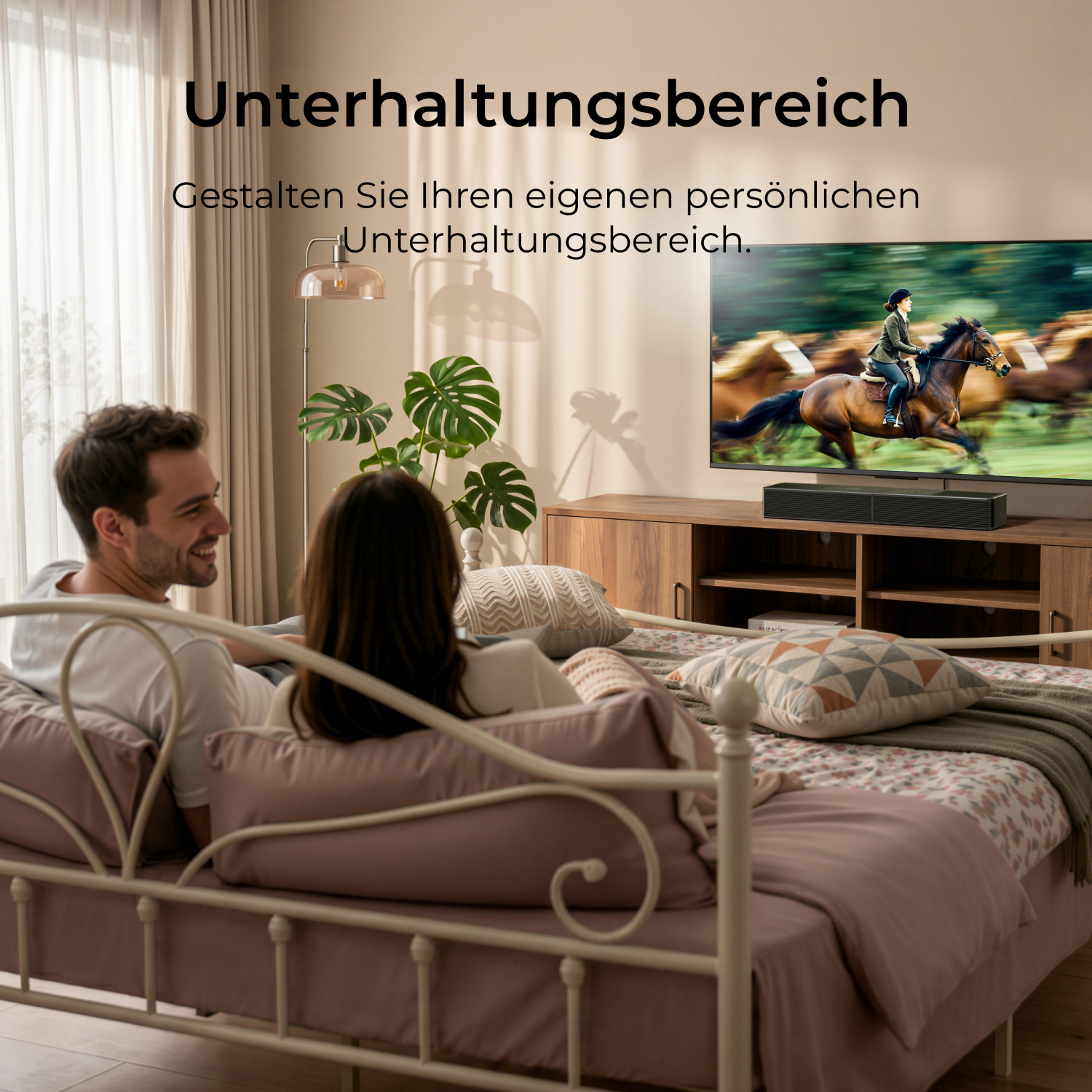 Ein Paar entspannt auf einem Bett, schaut fern. Ein Pferderennen läuft.