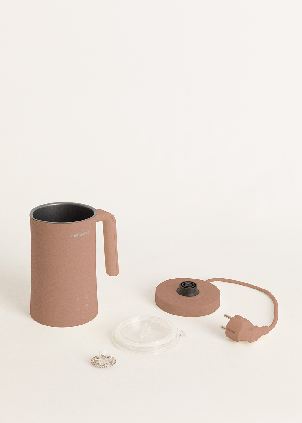 Un espumador de leche rosa con asa, tapa, accesorio espiral y enchufe.