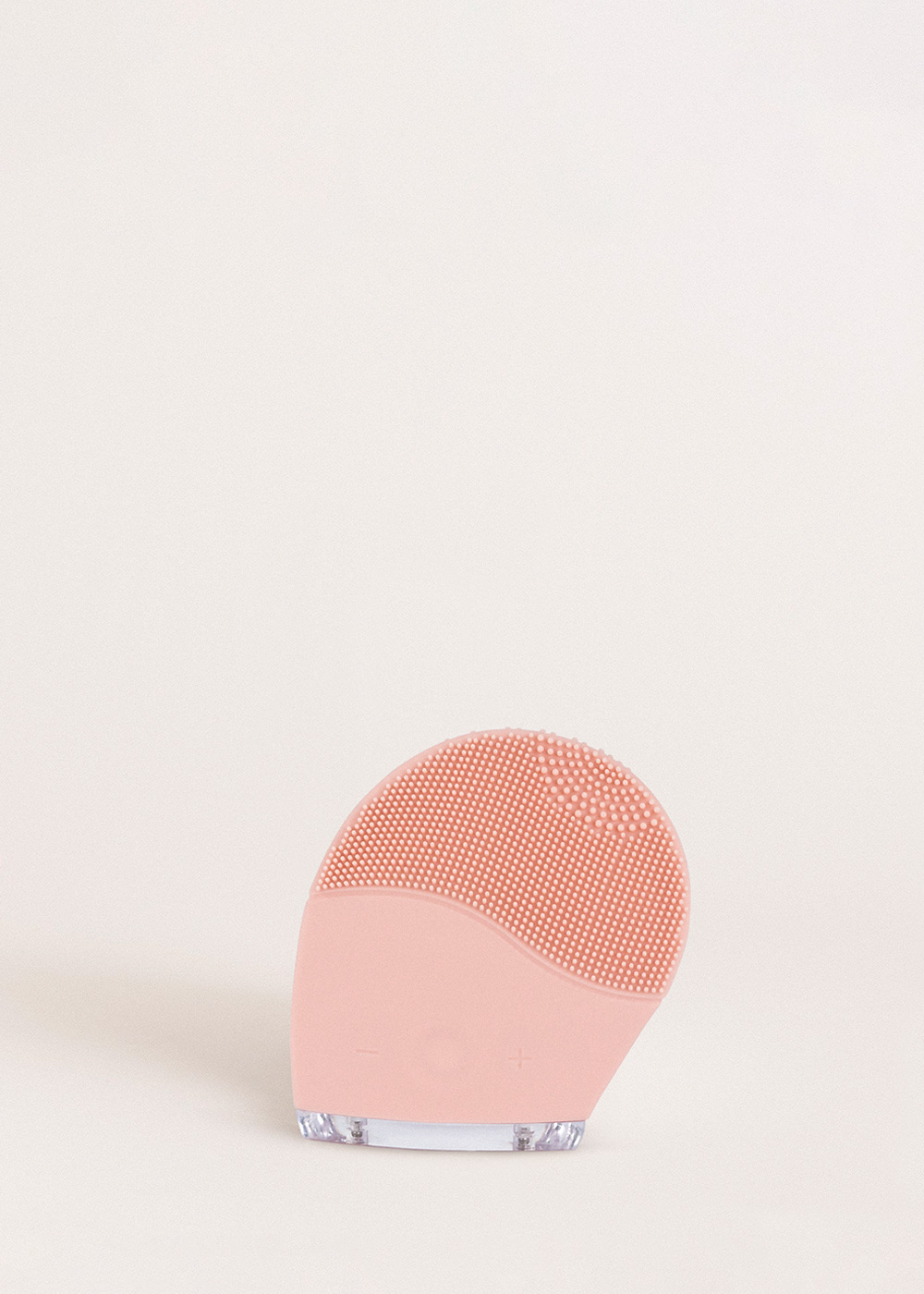 Un cepillo limpiador facial rosa con cerdas de silicona y base transparente.