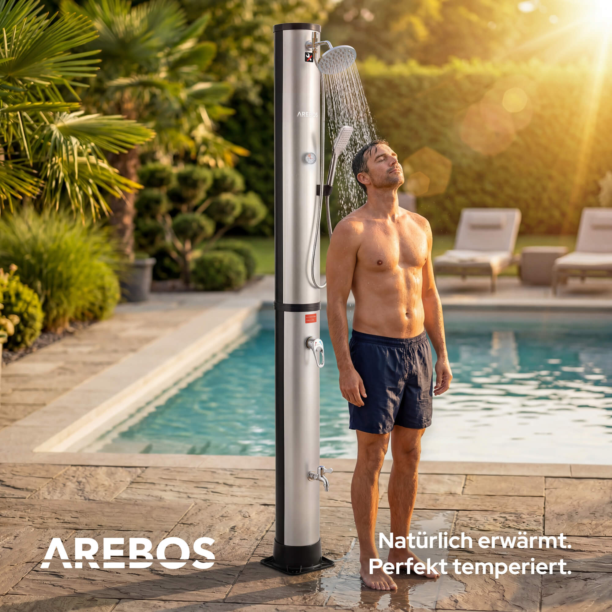 Mann duscht draußen neben Pool, Sonnenschein, Palmen und Liegestühle.