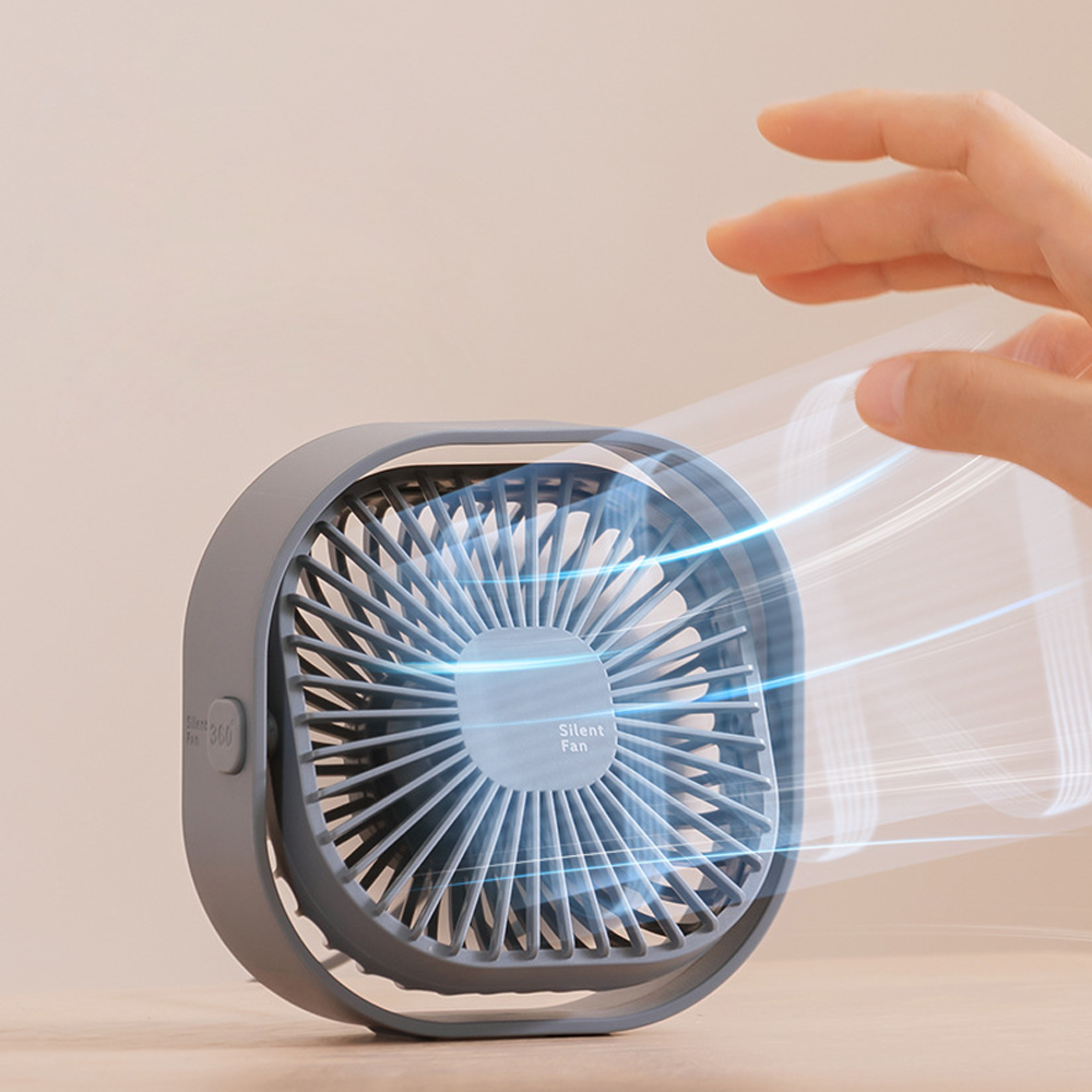 Grauer Ventilator mit blauen Luftströmen, eine Hand nähert sich.