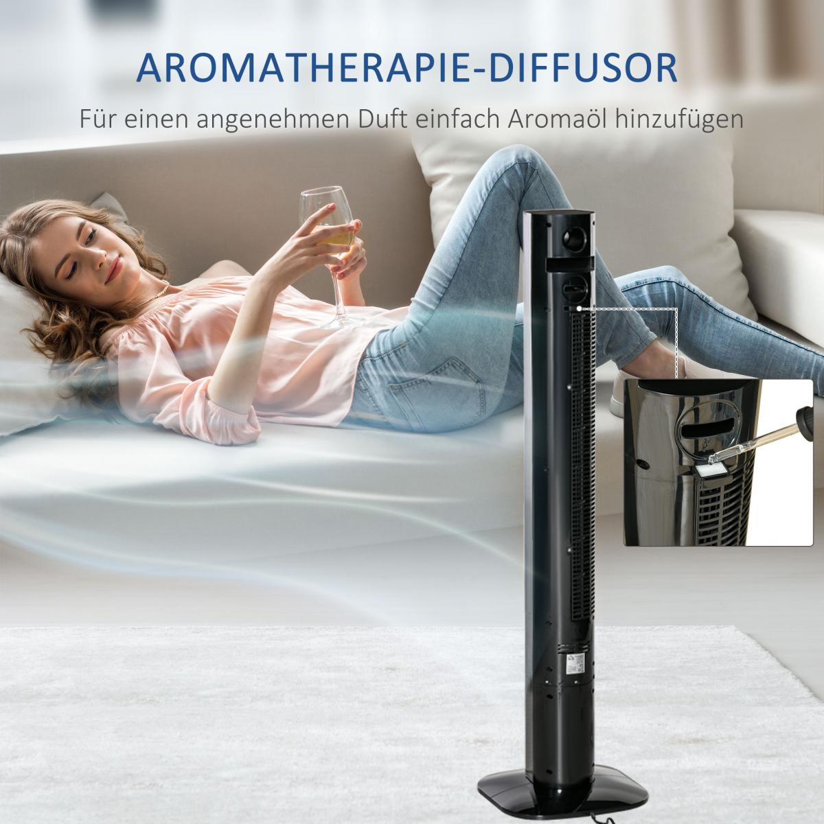 Eine Frau liegt auf einem Sofa und trinkt ein Glas. Ein Turmventilator steht daneben.