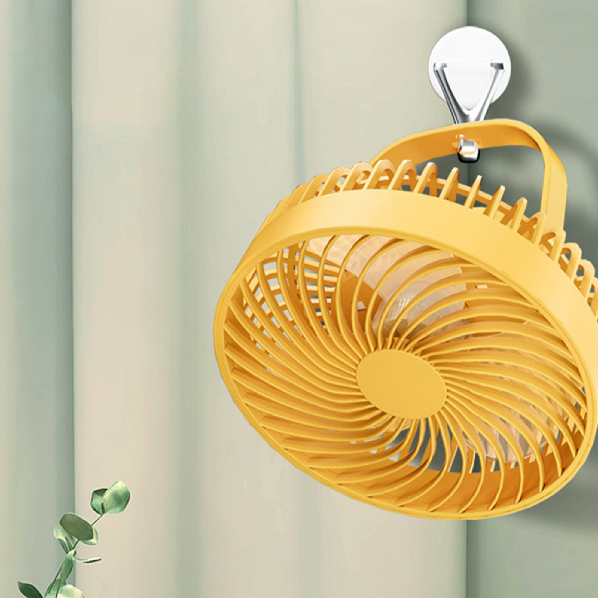 Ein gelber Ventilator hängt an einem Haken an der Wand.