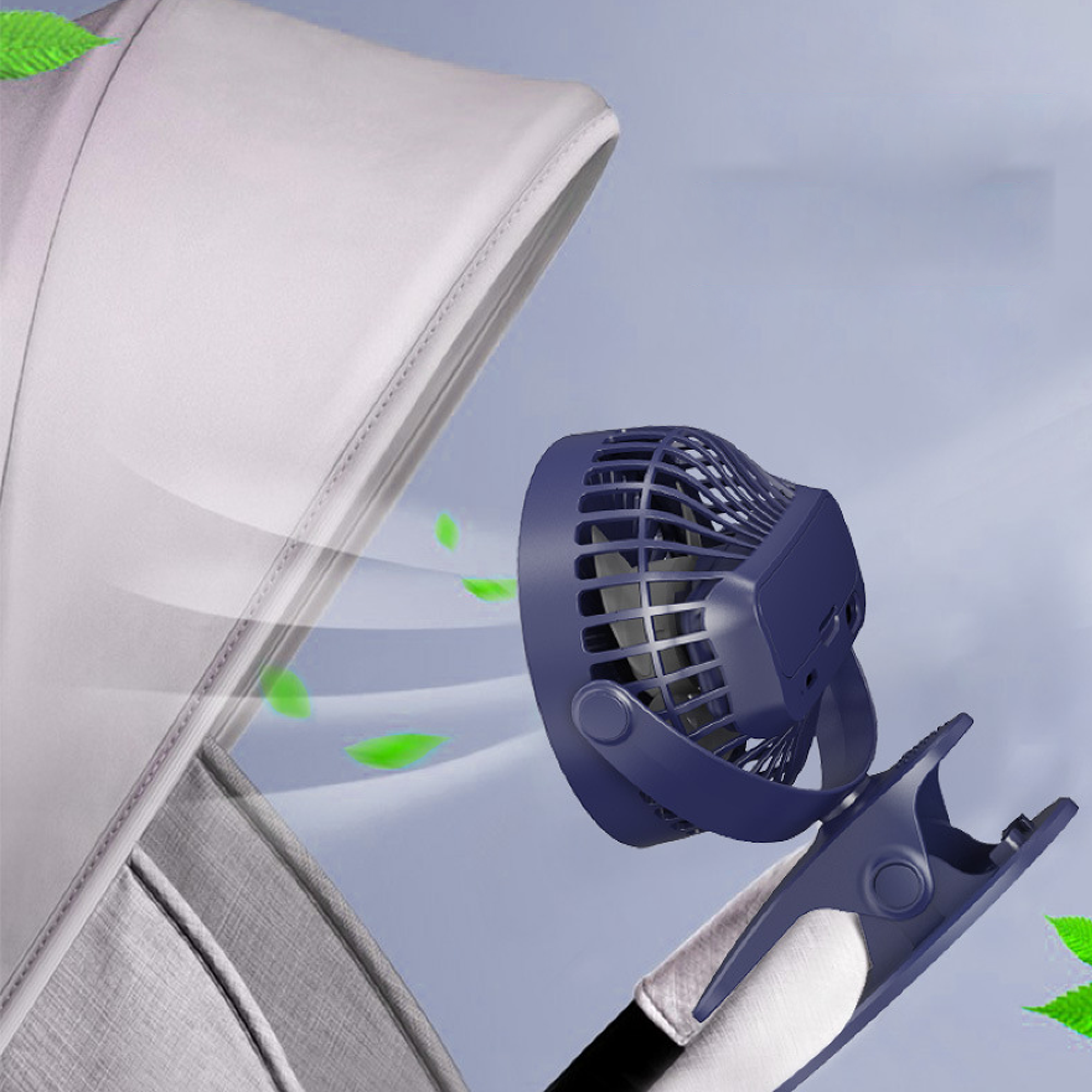 Ein blauer Clip-Ventilator an einem Kinderwagen-Verdeck, mit grünen Blättern.