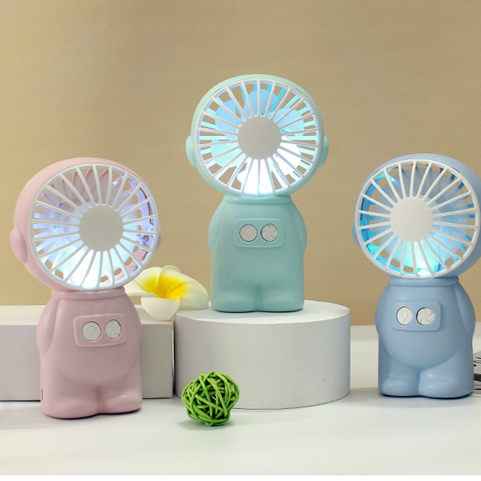 Drei niedliche Roboter-Ventilatoren in Rosa, Mintgrün und Blau mit beleuchteten Flügeln.