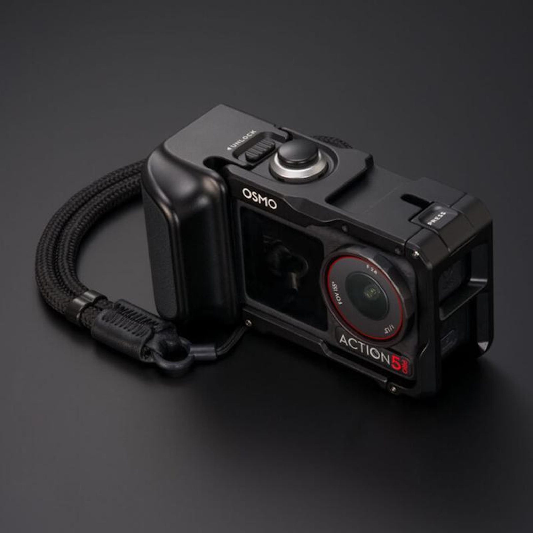 Action camera nera con logo Osmo, obiettivo e cinturino da polso su sfondo scuro.