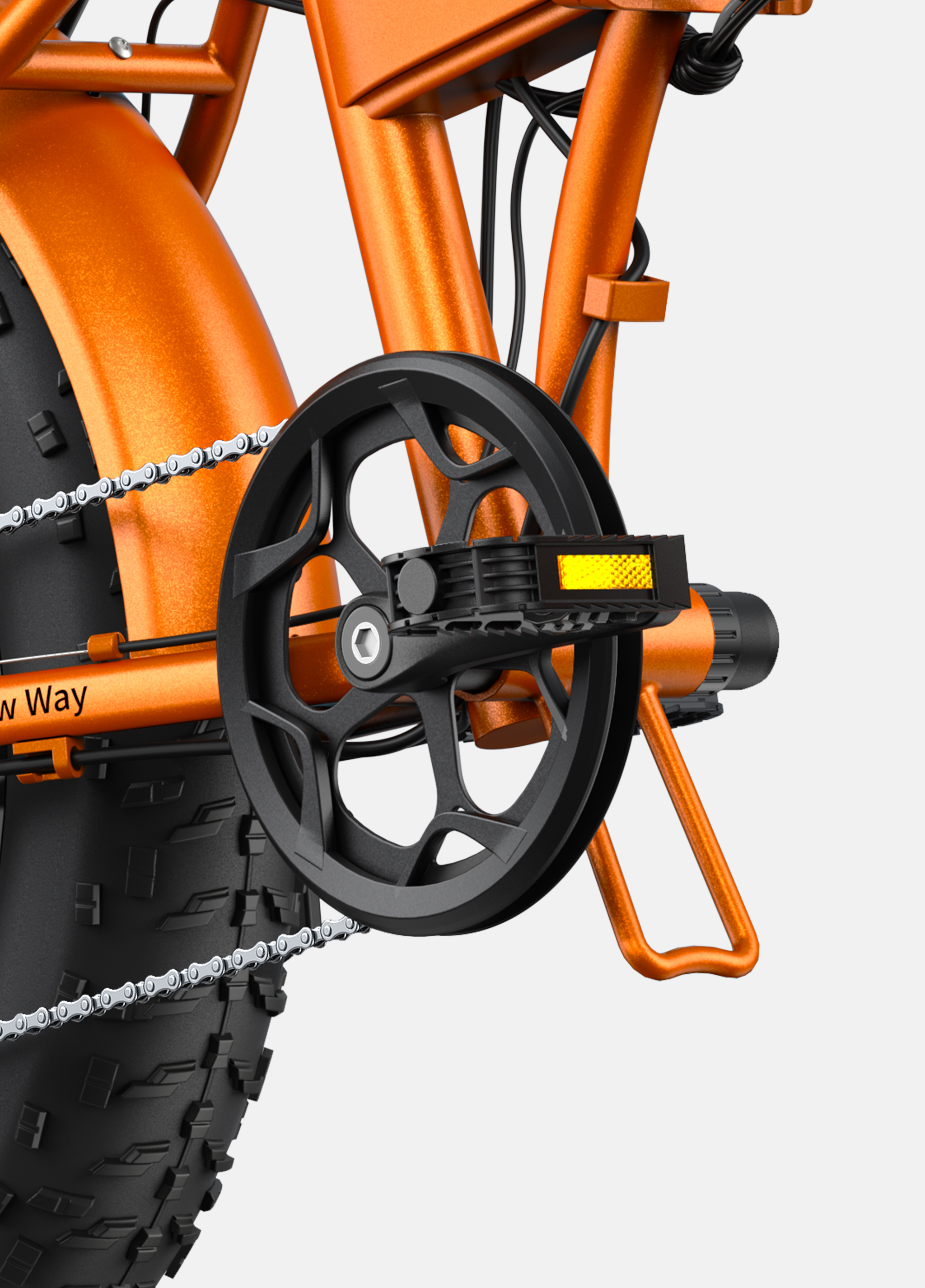 Primer plano de la cadena, el juego de bielas y el neumático grueso de una bicicleta naranja.