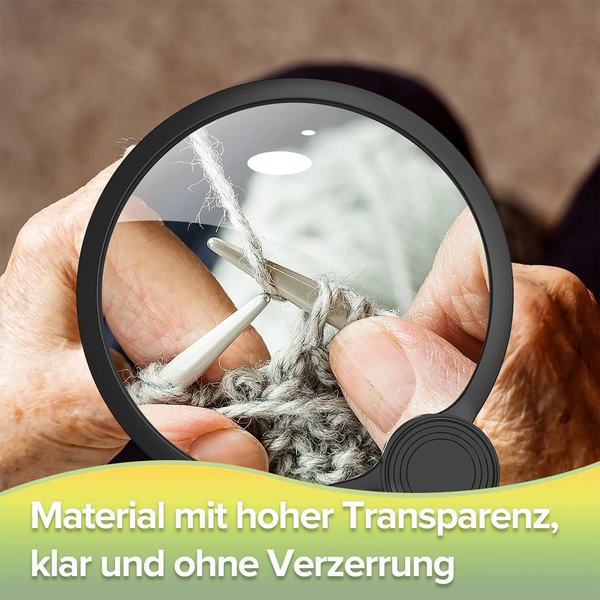 Lupe über Händen, die stricken. Detail des Garns und der Nadeln.