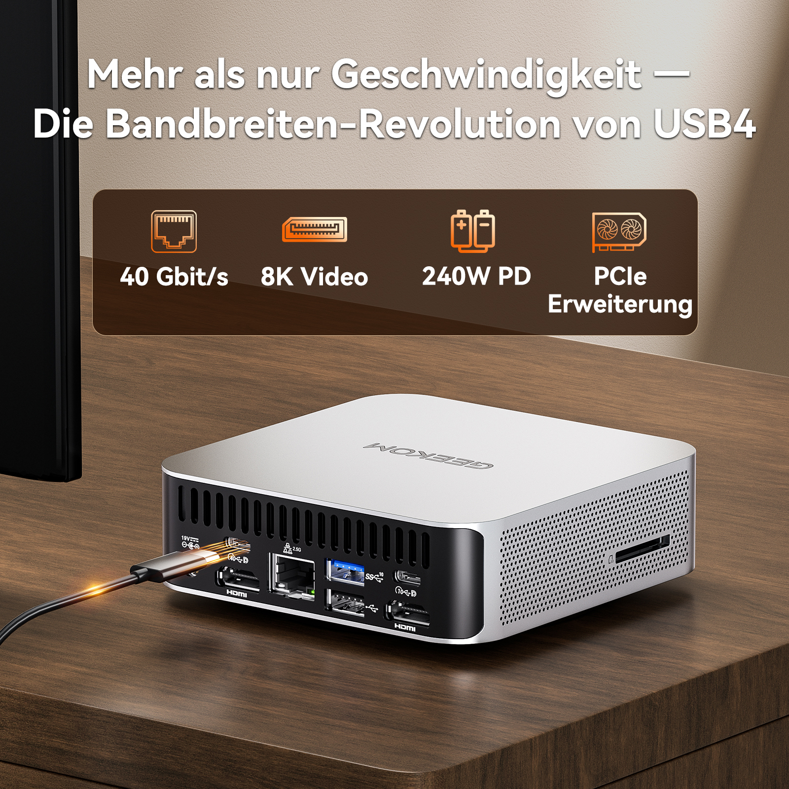Ein silberner Mini-PC mit einem Kabel angeschlossen, auf einem Holztisch.
