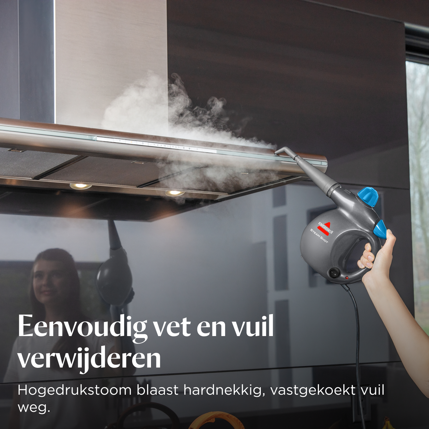Hand hält Dampfreiniger, reinigt Dunstabzugshaube. Dampf steigt auf.