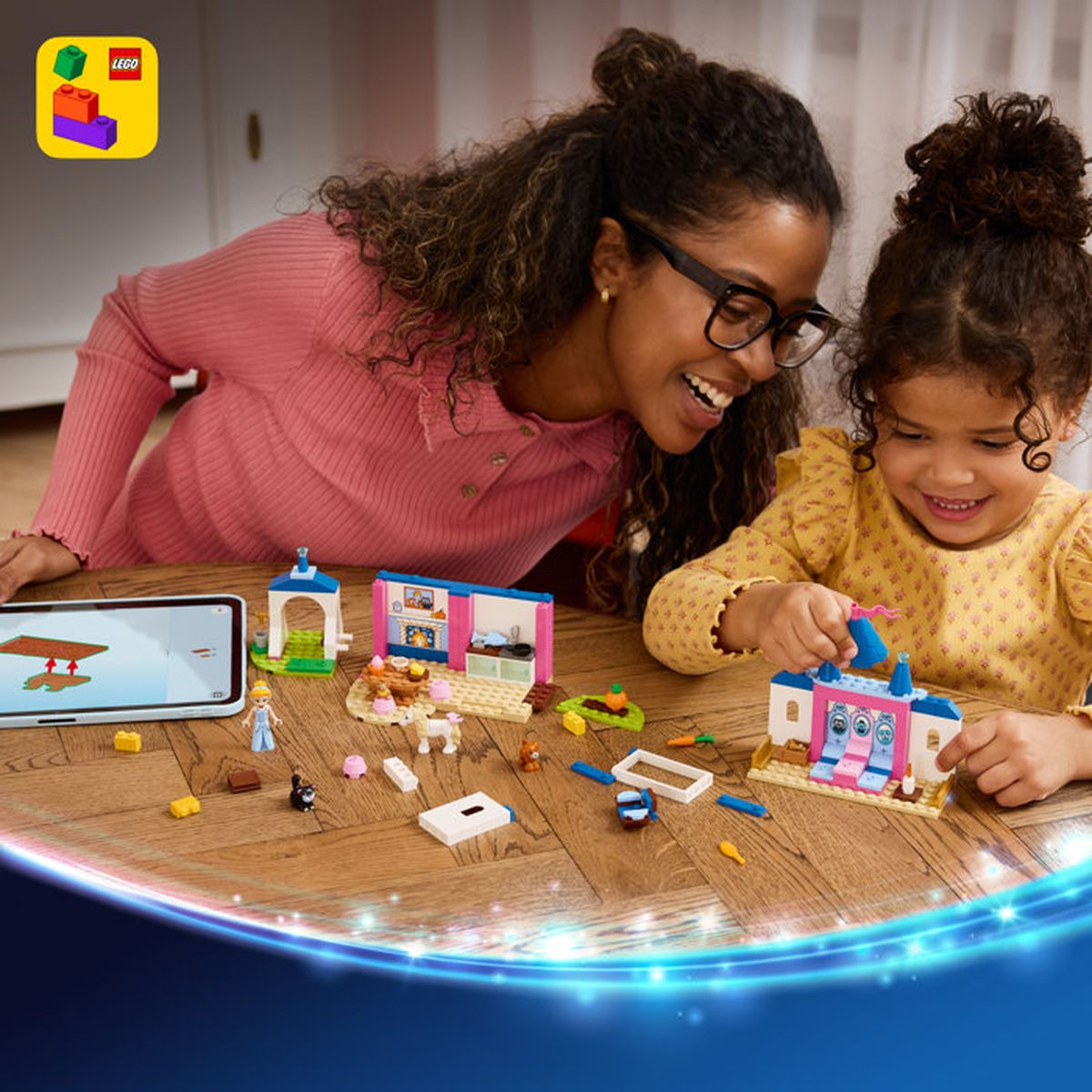 Mujer y niña construyen con bloques de Lego en una mesa de madera.