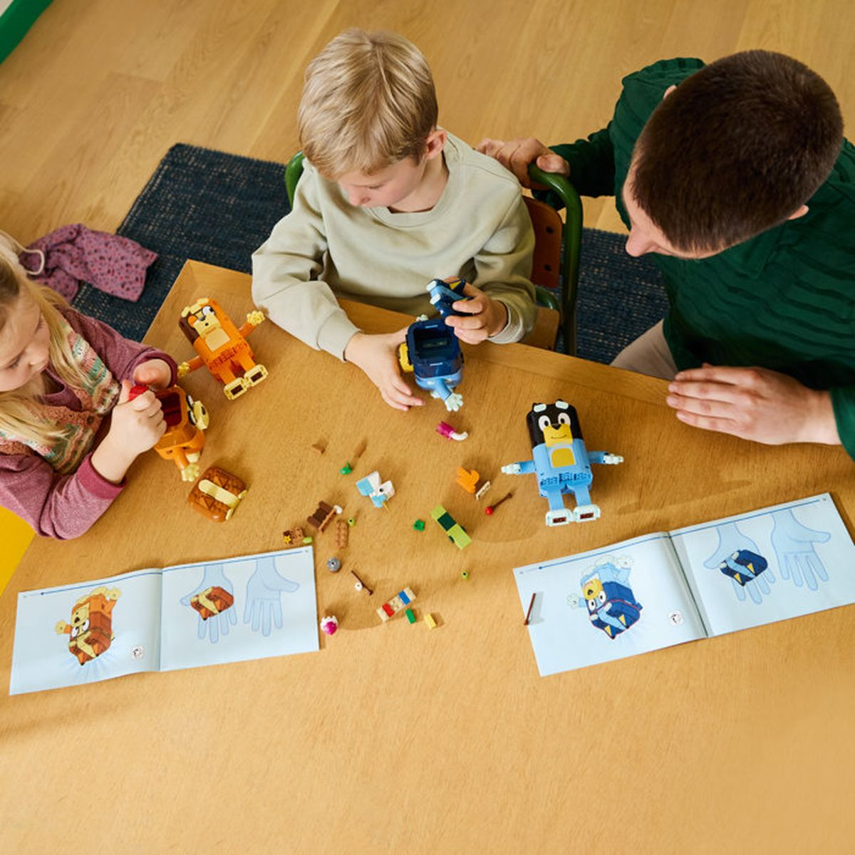 Familia construyendo figuras de Lego en una mesa de madera. Incluye instrucciones.