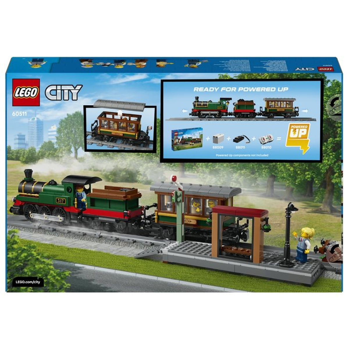 Yeşil bir Lego treni yolcu vagonlarıyla peron yanında raylarda duruyor.