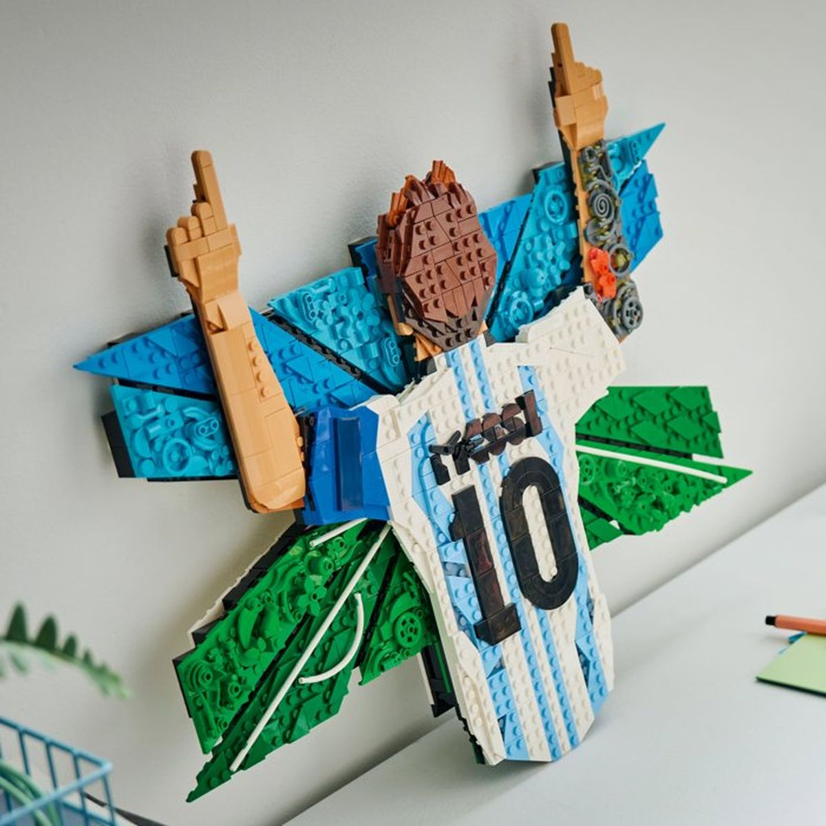Lego Messi figürü, beyaz ve mavi forma, 10 numara, kahverengi saçlı.