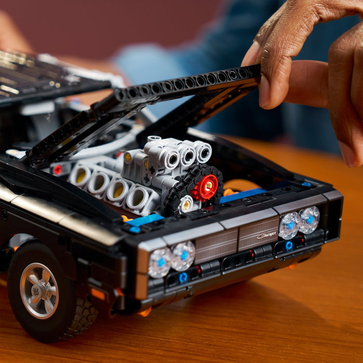 Açık kaputlu siyah bir Lego araba, V8 motorunu gösteriyor.