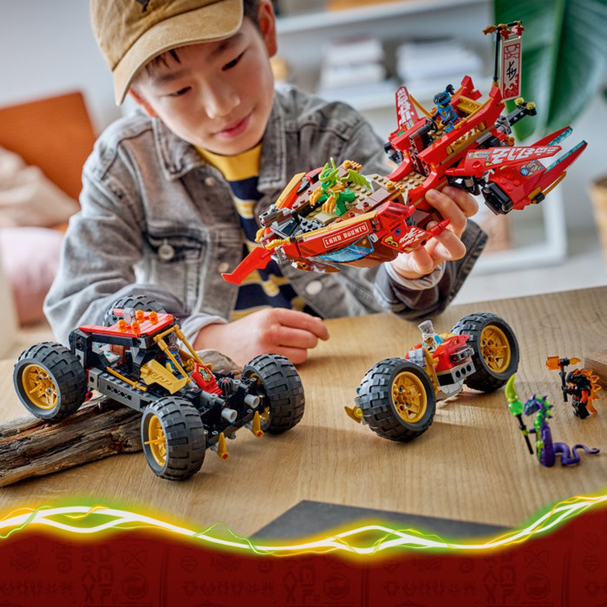 Un niño juega con juguetes de Lego, incluyendo un barco rojo y dos vehículos.