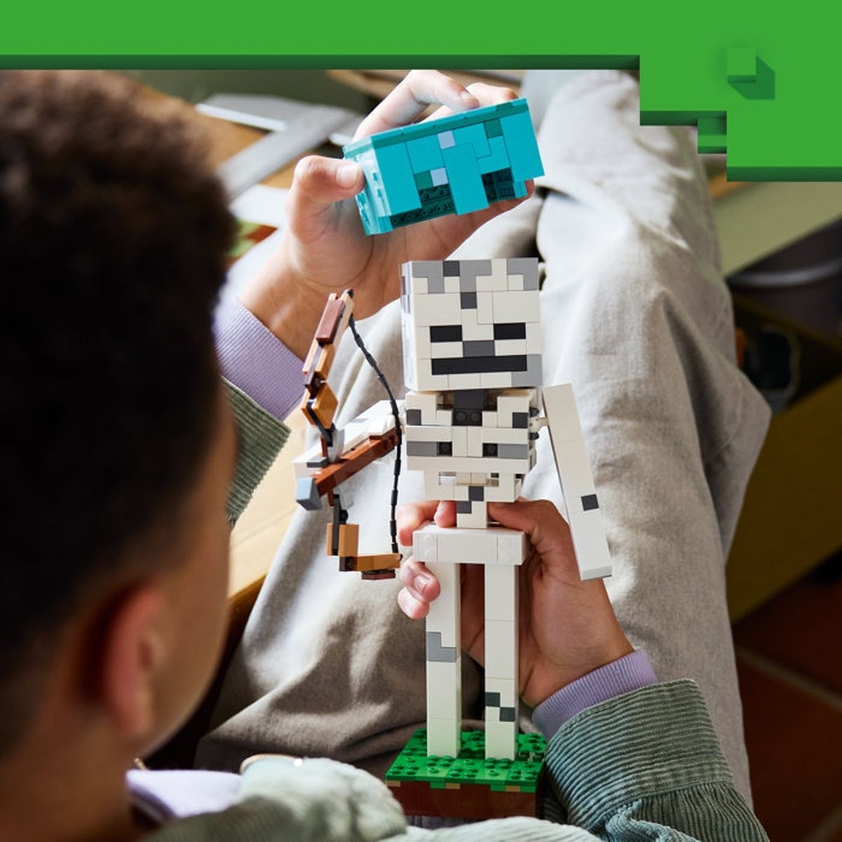 Una persona sostiene un juguete de esqueleto de Minecraft y una figura azul.