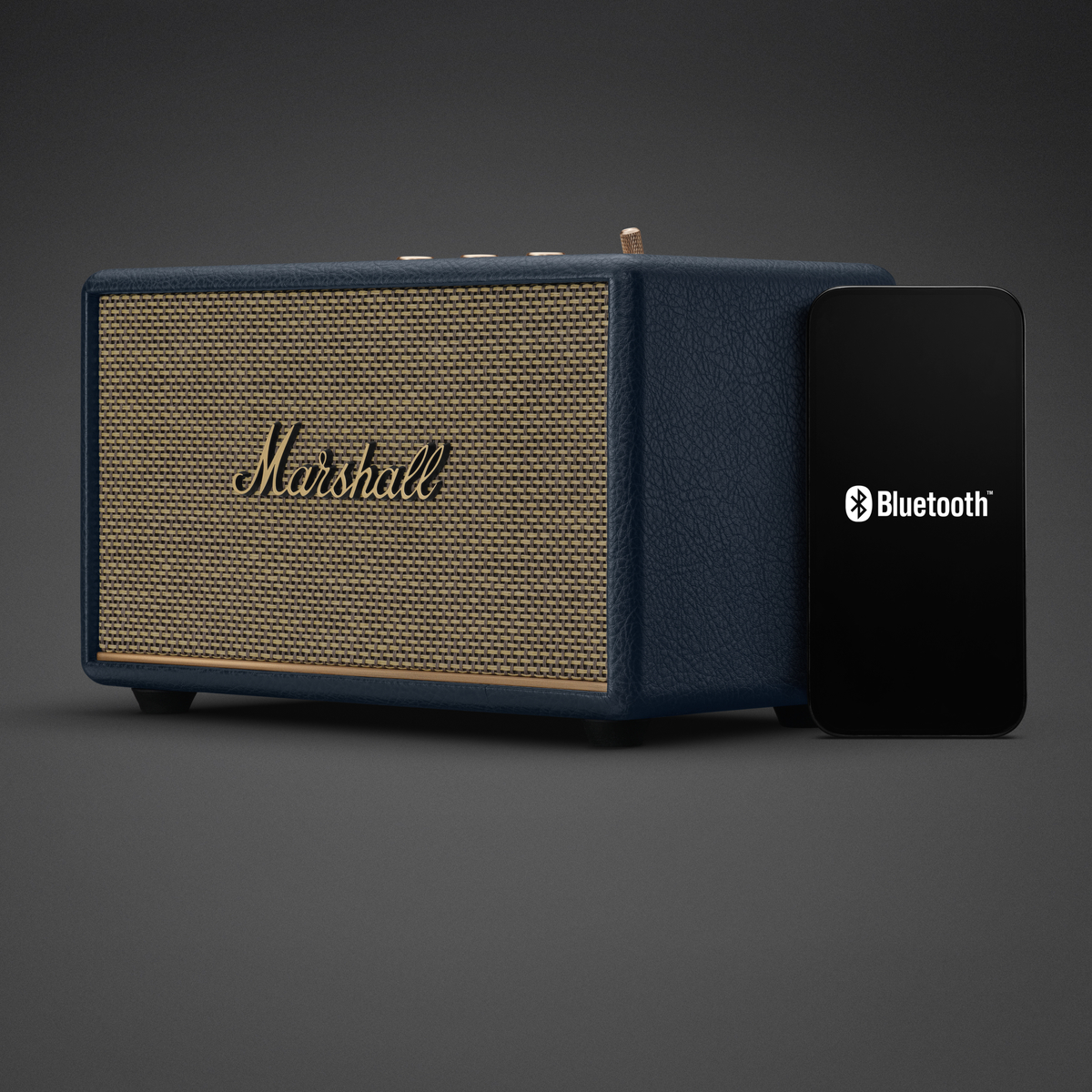Ein blauer Marshall Lautsprecher neben einem Smartphone mit Bluetooth-Symbol.