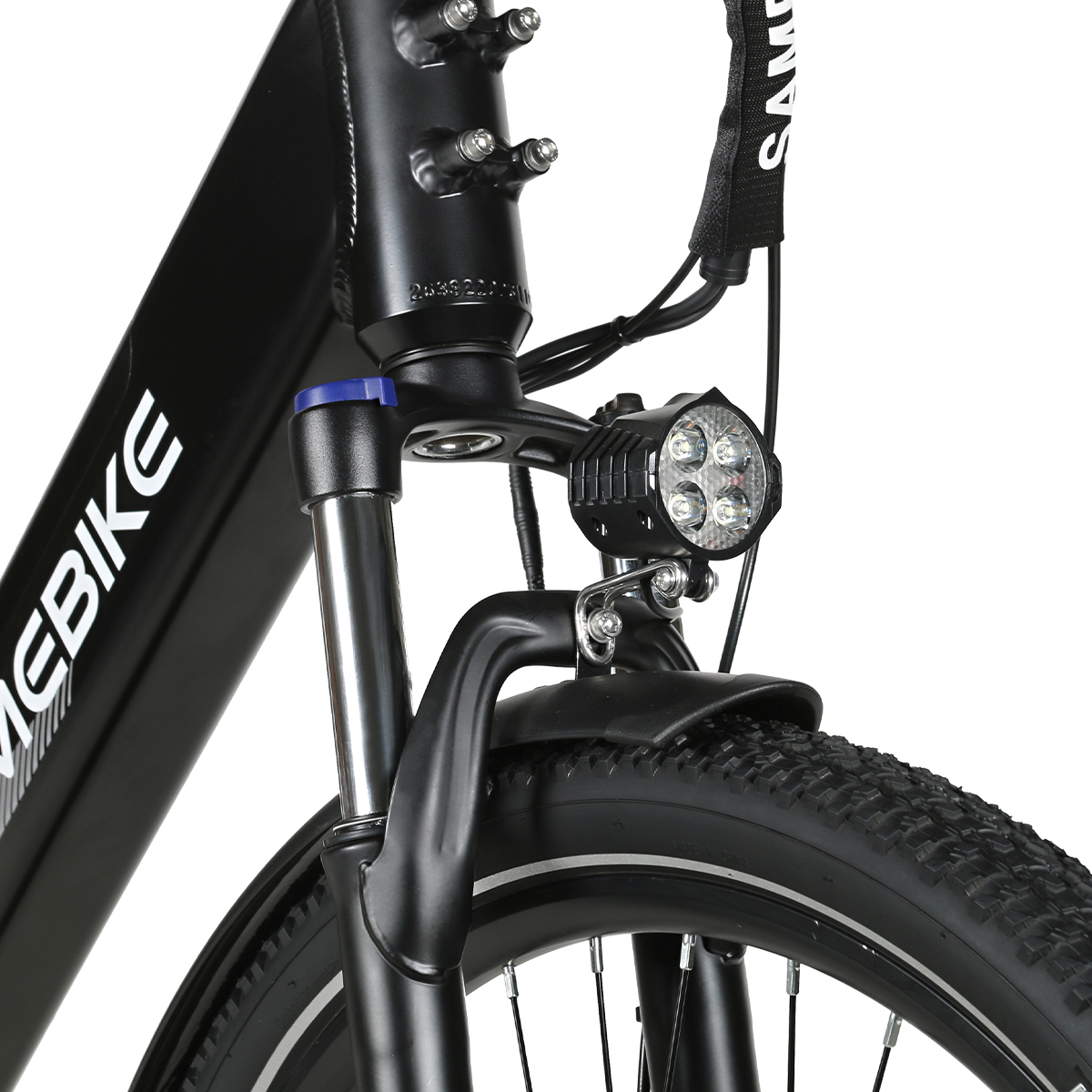 Primo piano della forcella di una e-bike nera con faro e ruota anteriore.