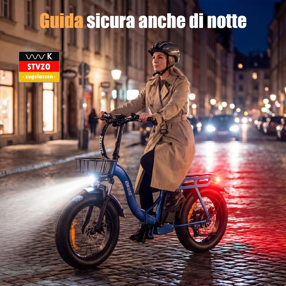 Una donna guida una bici elettrica blu in una strada cittadina illuminata di notte.