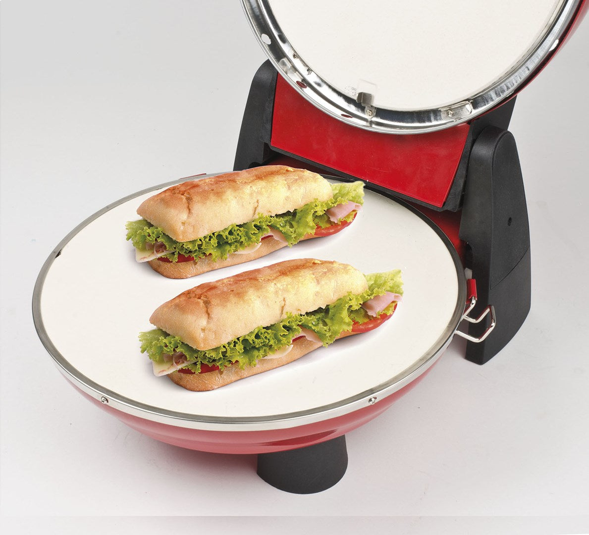 Dos sándwiches con lechuga, tomate y jamón en una sandwichera roja.