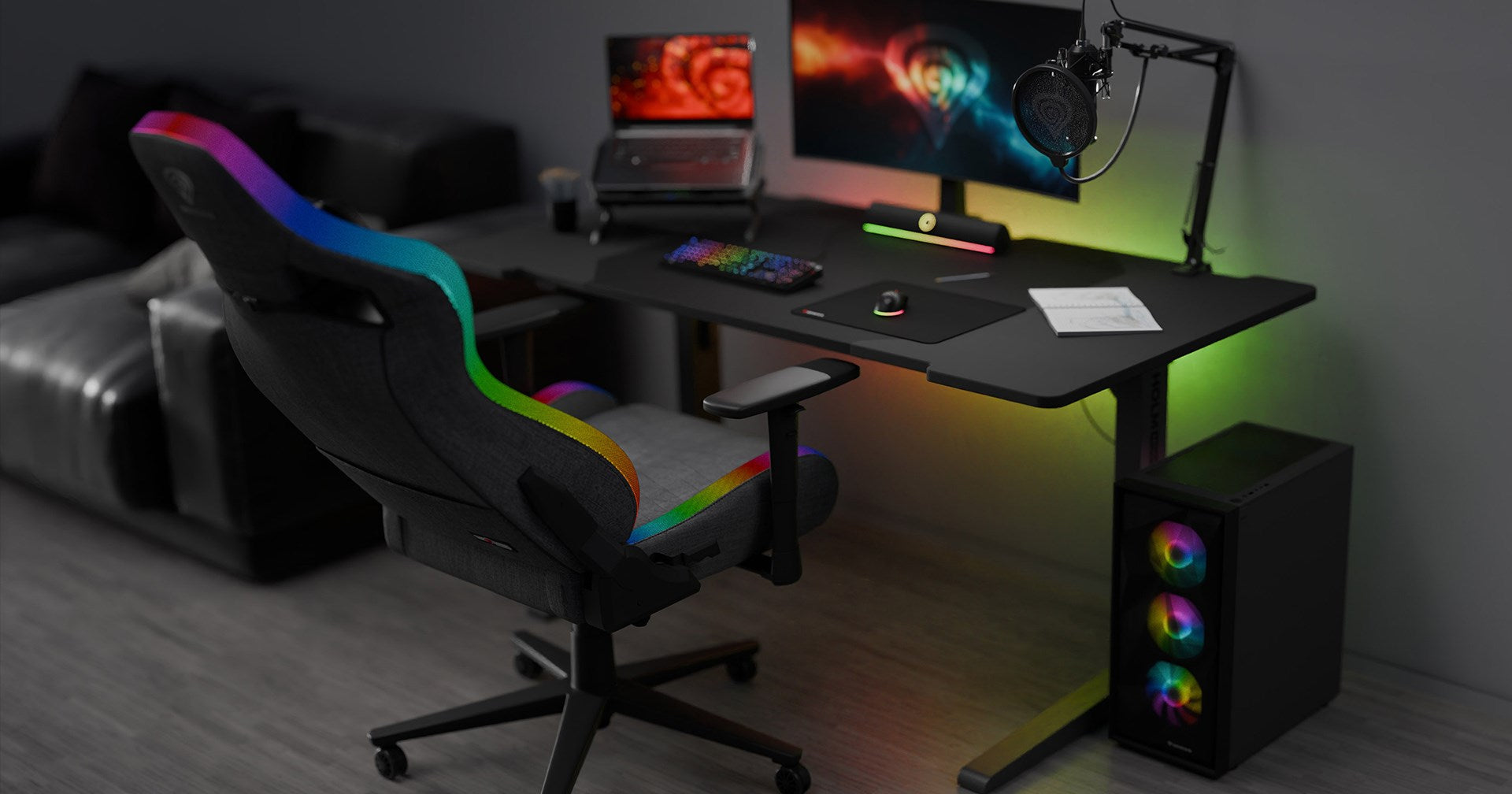 Ein Gaming-Schreibtisch mit Stuhl, PC und Monitor, beleuchtet mit RGB-Licht.