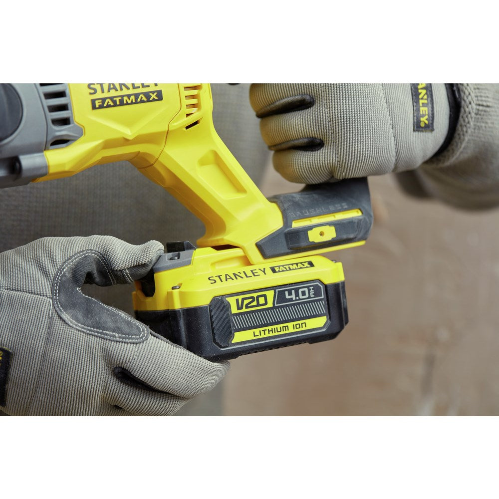 Manos con guantes grises sostienen una batería amarilla Stanley Fatmax de 20V 4.0Ah.