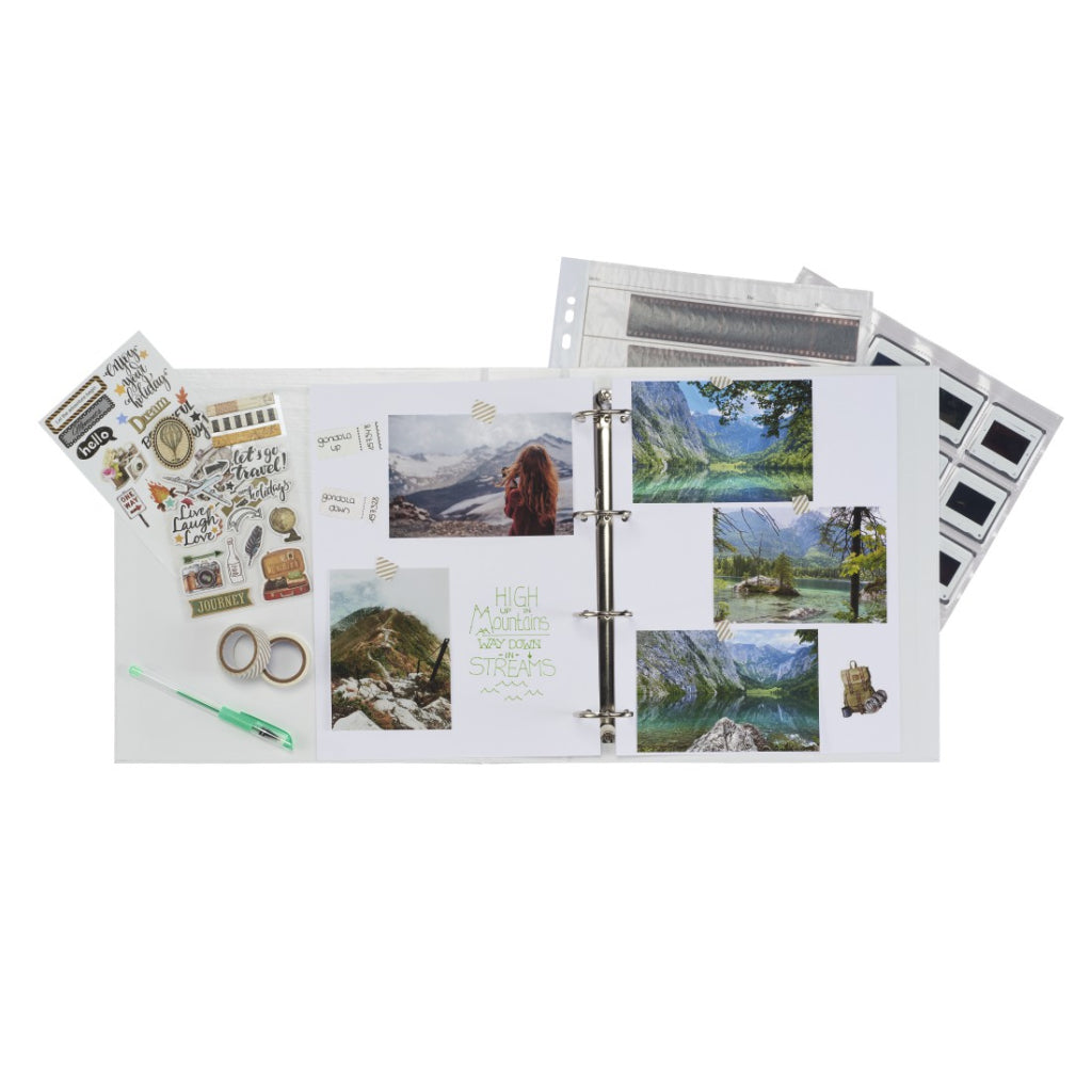 Aufgeschlagenes Scrapbook mit Reisefotos, Stickern, Klebeband, Stift und Fotoseiten.