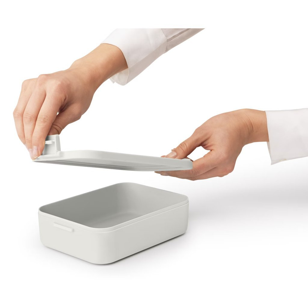 Contenitore grigio con manici tenuto da mani con coperchio abbinato.