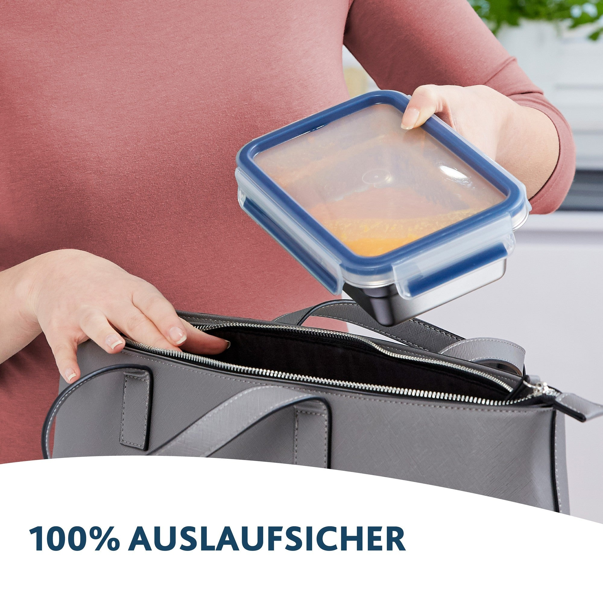 Eine Person legt eine durchsichtige Aufbewahrungsbox in eine graue Tasche.