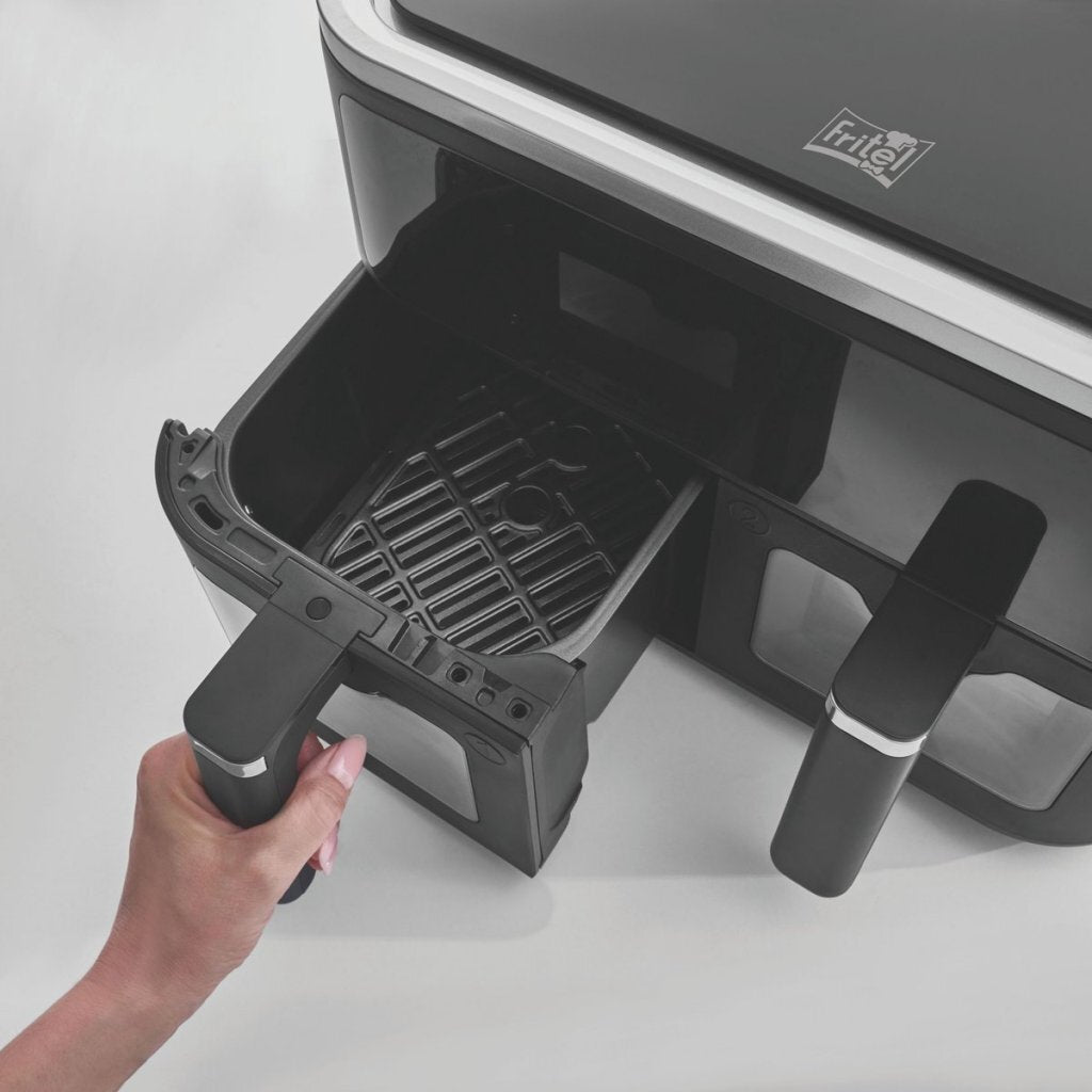 A hand pulls a drawer from a black air fryer appliance.