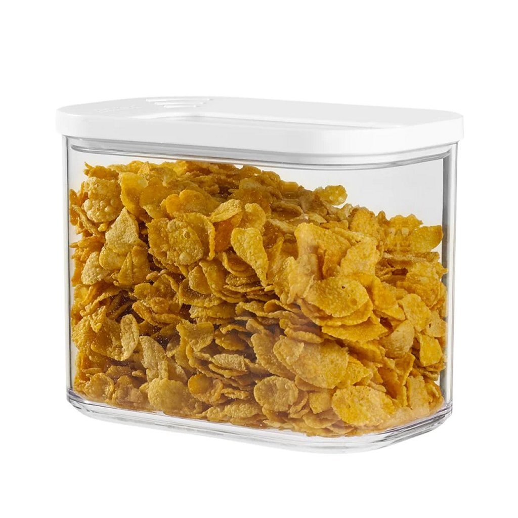 Ein klarer Behälter gefüllt mit goldenen Cornflakes und einem weißen Deckel.