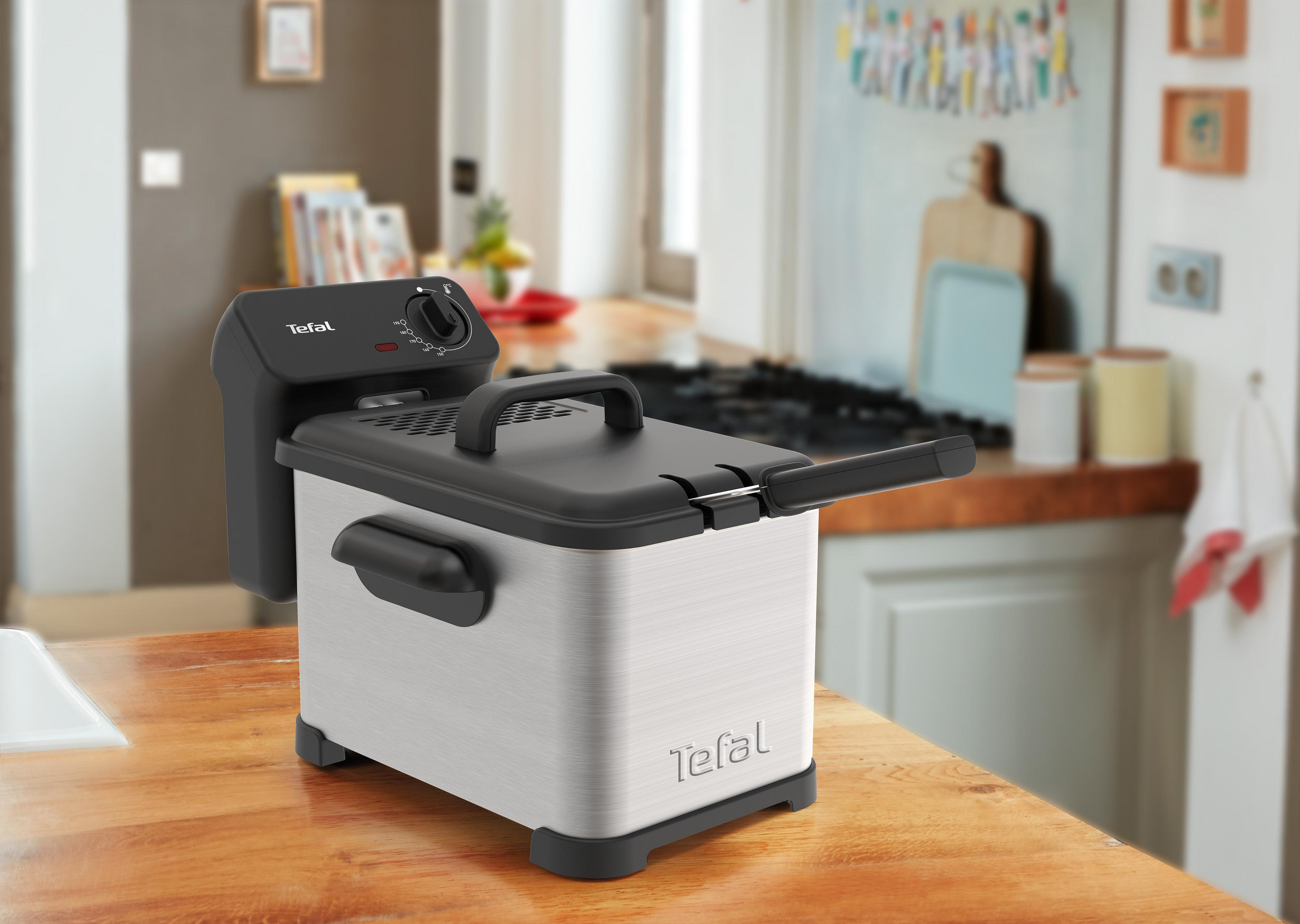 Una friggitrice Tefal su un tavolo di legno in una cucina.