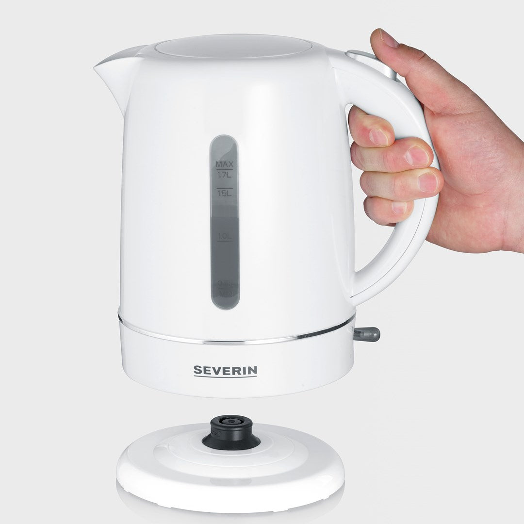 Une main tient une bouilloire électrique blanche, capacité max 1,7 L. La base est à côté.