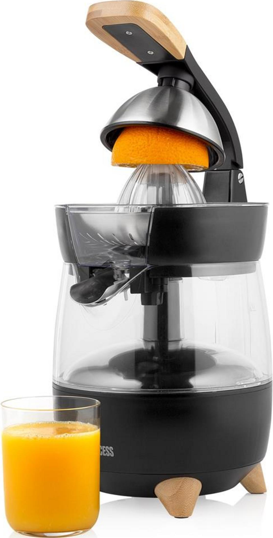 Elektrische citruspers met glas en sinaasappelhelft.