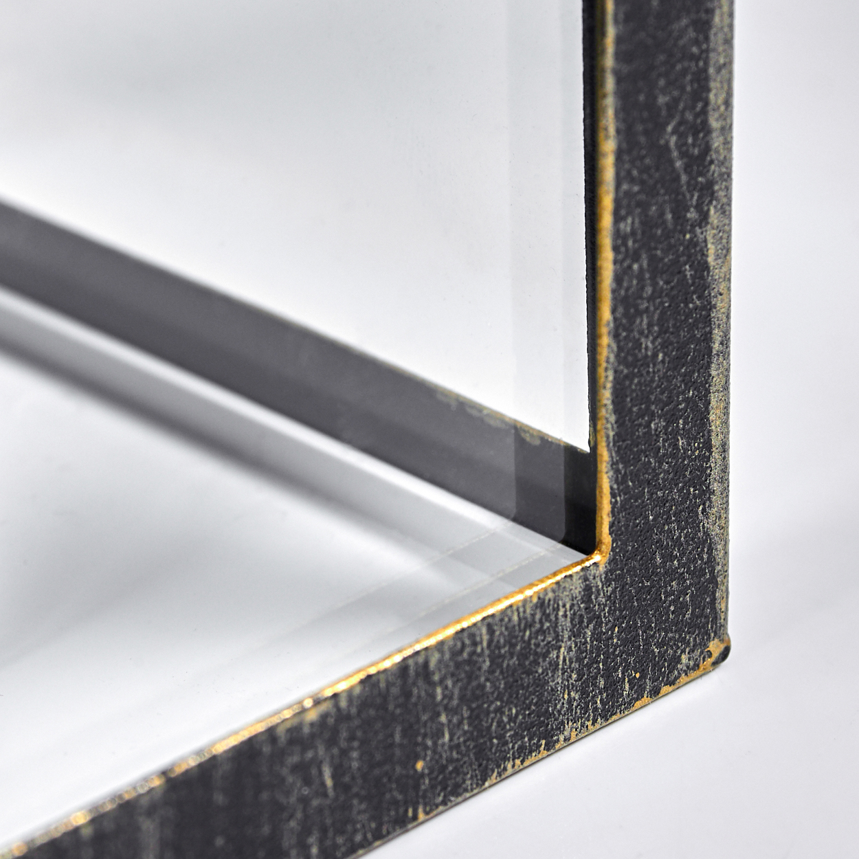 Dunkler Metallrahmen mit goldener Kante und Glas auf weißem Hintergrund.