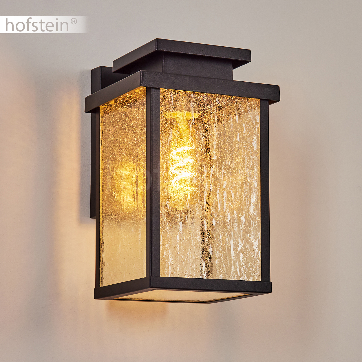Eine schwarze Wandleuchte mit strukturiertem Glas und sichtbarer Glühbirne.