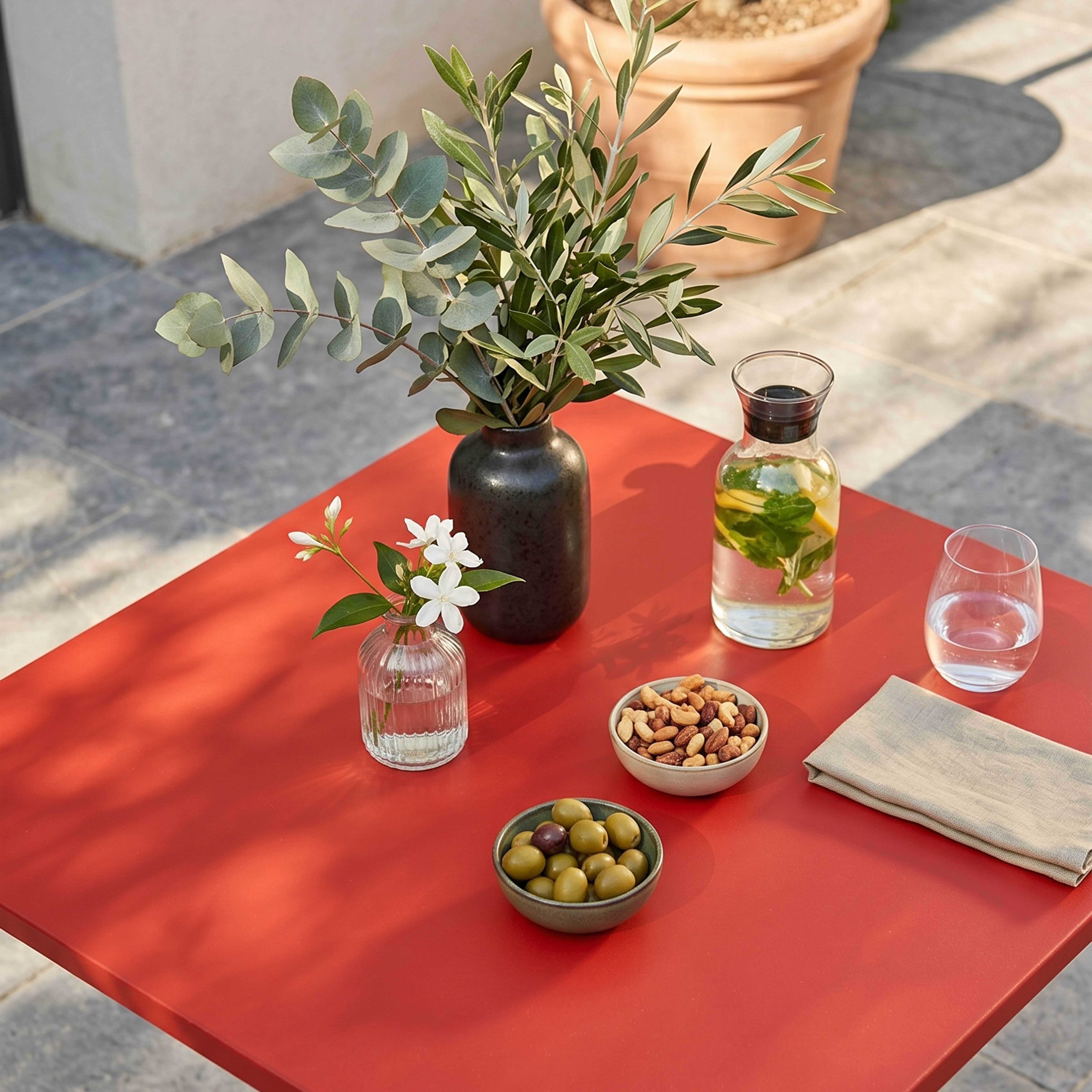 Ein roter Tisch mit Snacks und Getränken im Freien.