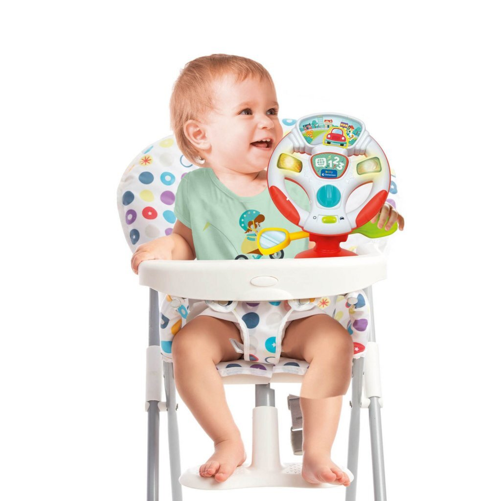 Un bambino seduto su un seggiolone gioca con un volante giocattolo colorato.