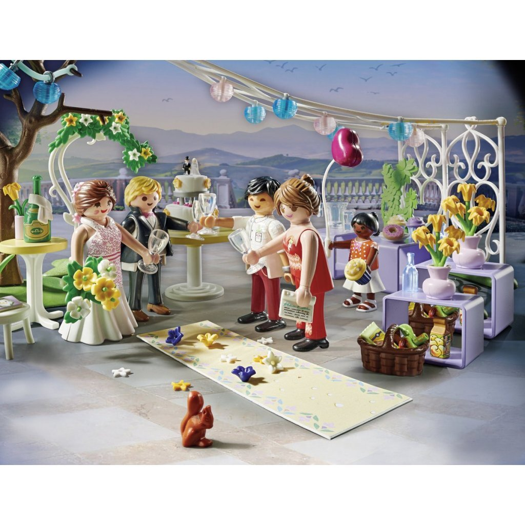 Escena de boda Playmobil con pastel, novia, novio, invitados y decoraciones.