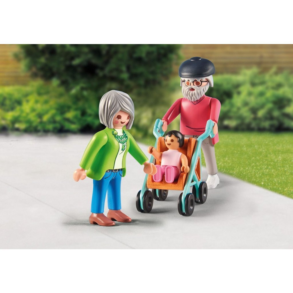 Ein älteres Paar schiebt einen Kinderwagen mit einem Baby darin auf einem Gehweg.