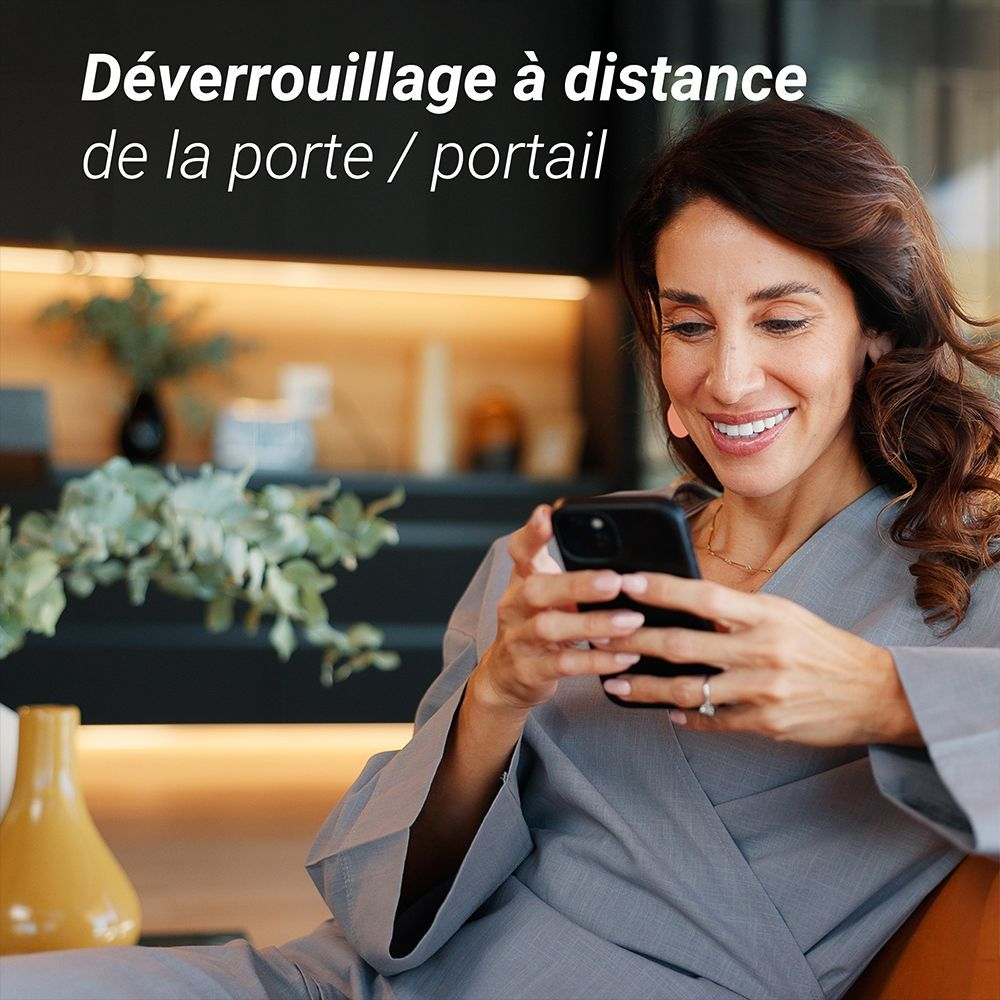 Una mujer sonríe mientras mira su teléfono inteligente.