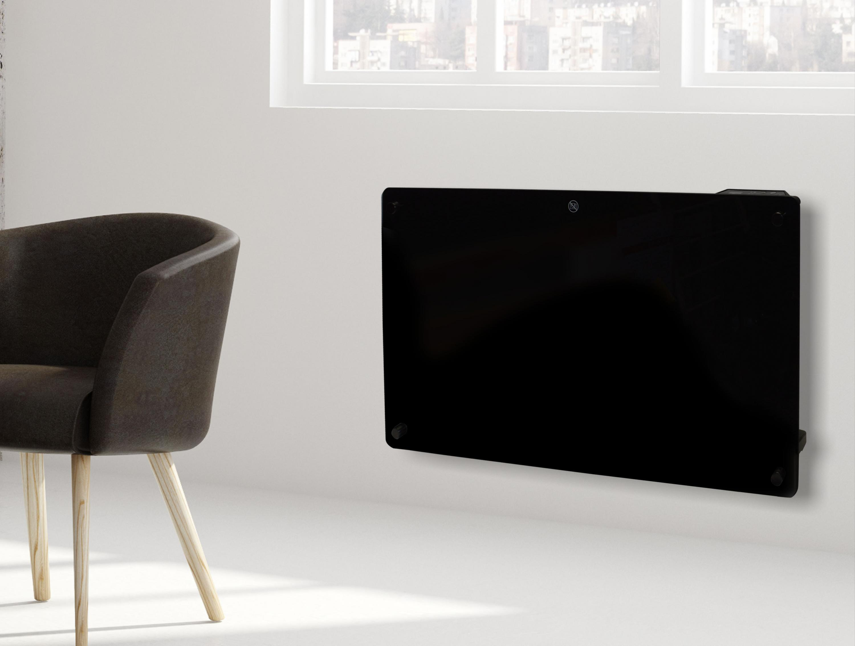 Un sillón oscuro junto a un radiador negro en una pared blanca.