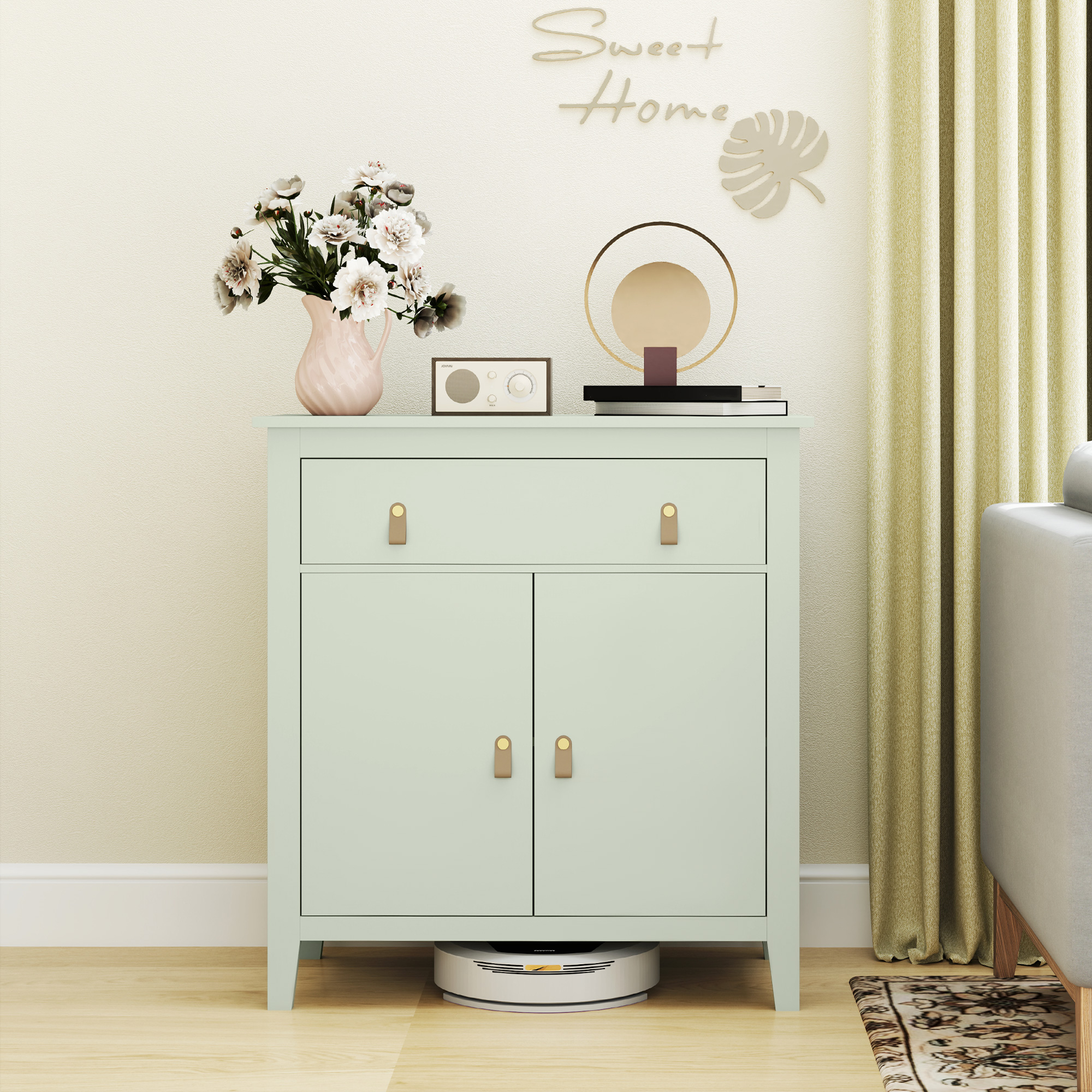 Un mueble verde menta con flores, radio y decoración. Un robot aspirador abajo.