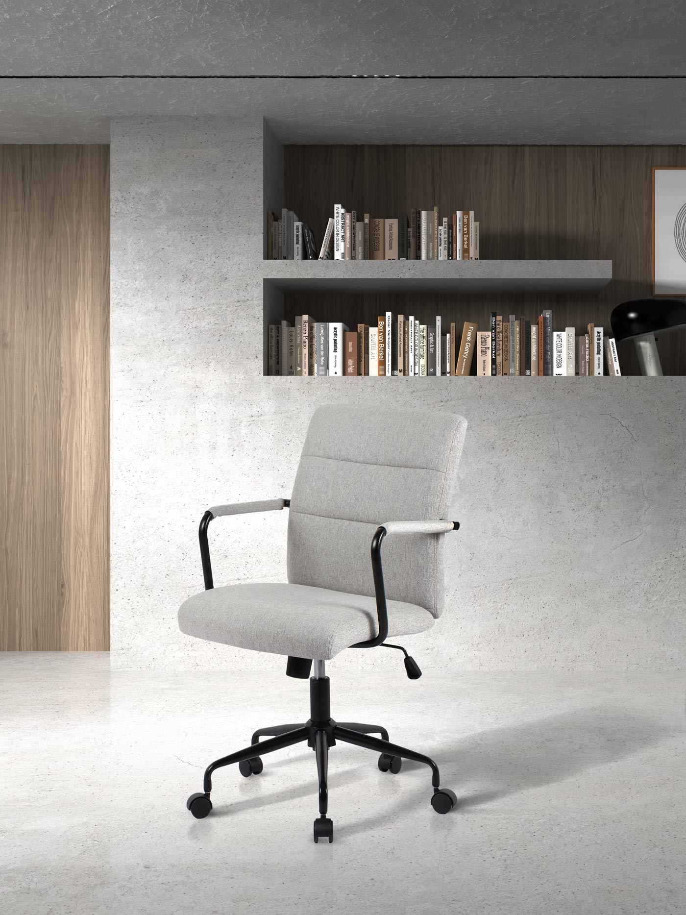 Una silla de oficina gris claro con base negra sobre suelo claro, delante de una estantería.