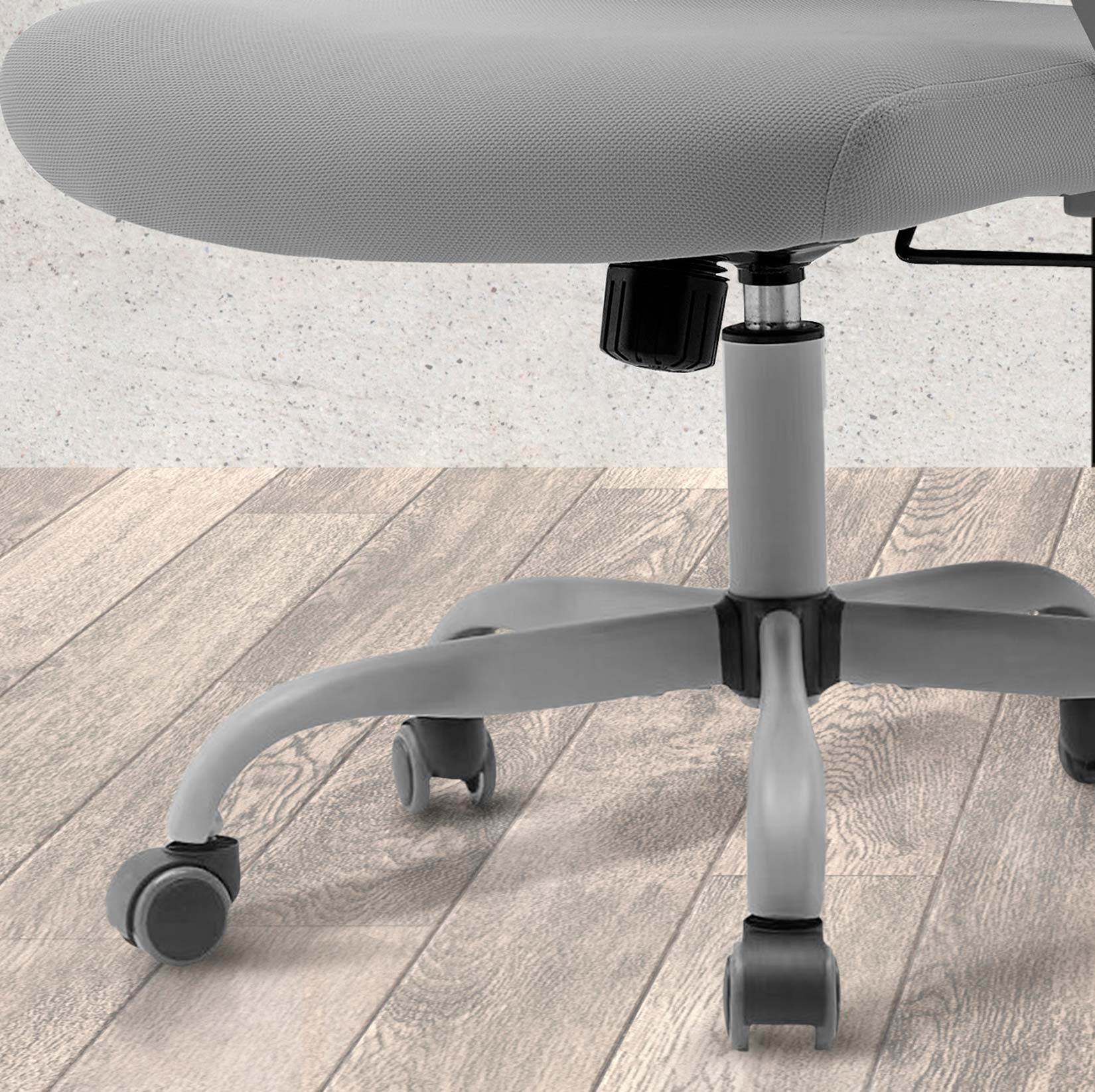 Silla de oficina gris con cinco ruedas sobre suelo de madera.