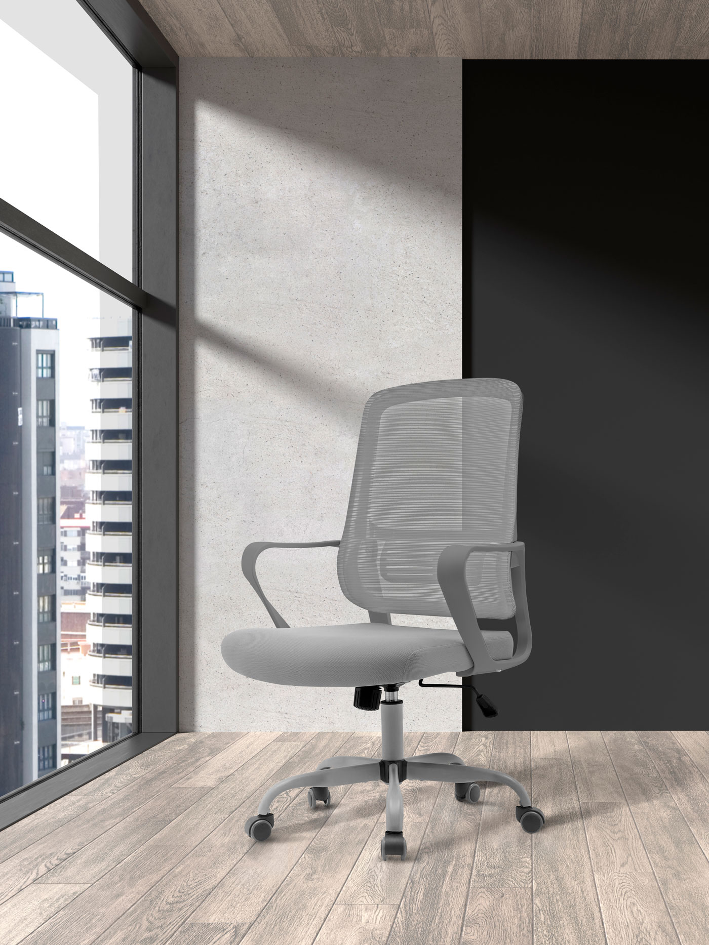 Silla de oficina de malla gris con reposabrazos sobre suelo de madera, junto a ventana con vistas.
