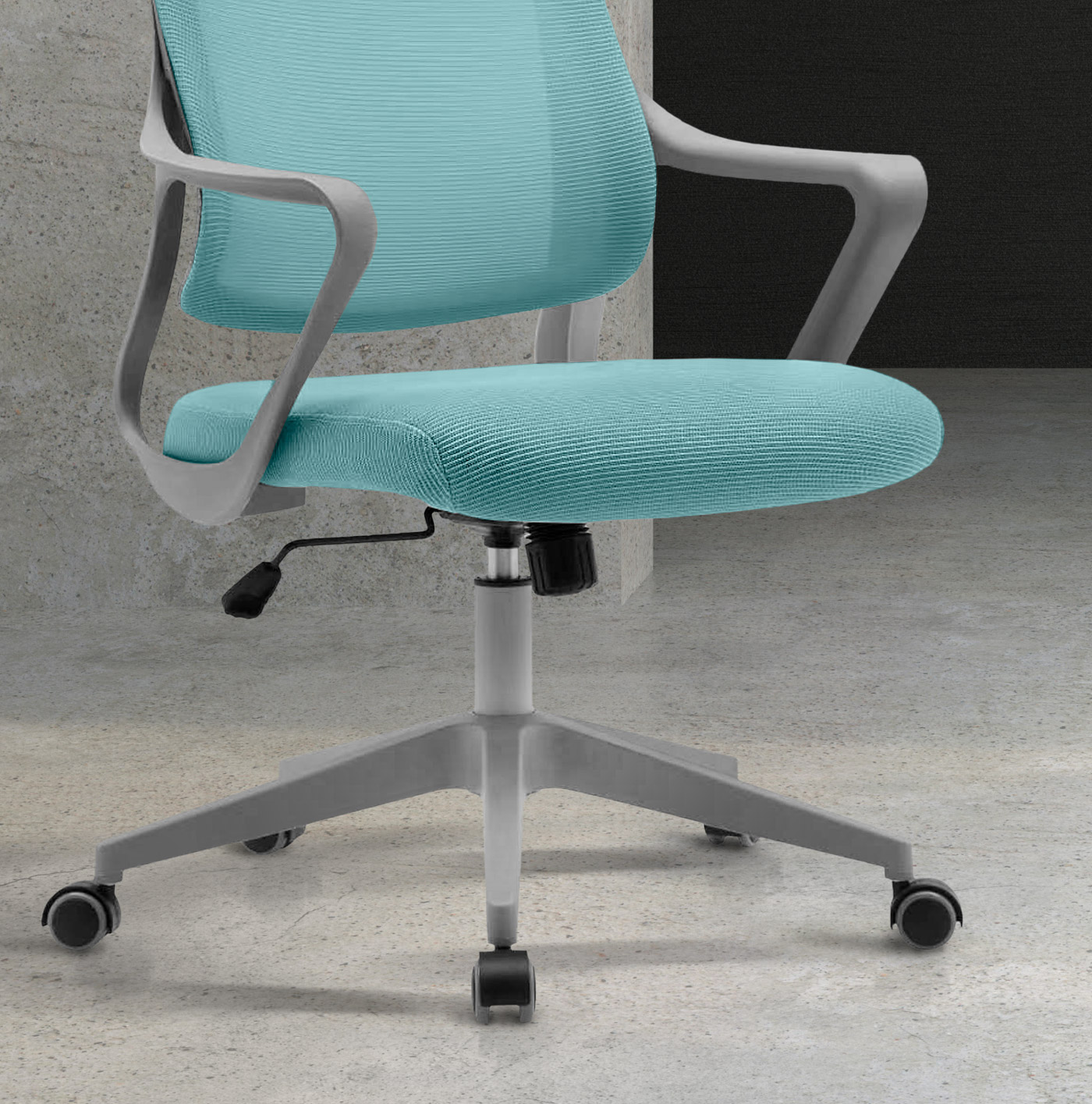 Primer plano de una silla de oficina de malla turquesa con brazos grises, sobre suelo de hormigón.